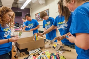 Students working on filling backpacks with supplies