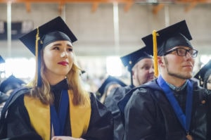 Eden Shaveet in her seat at graduation looking at the speaker