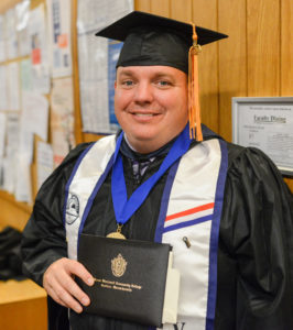 MWCC Veteran Student Tom Berger Standing in His Graduation Regalia with His Diploma