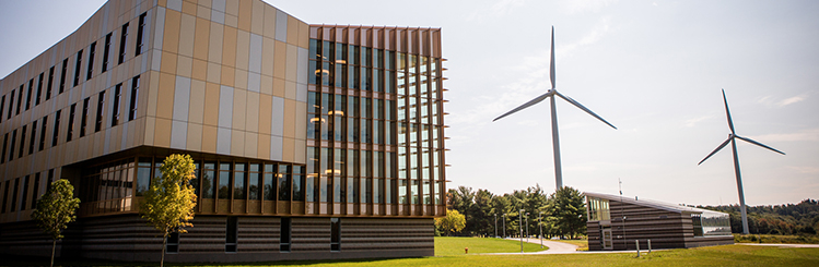 Front left angle of the Dr. Daniel M. Asquino Science Center with the windmills in the background on a sunny summer day