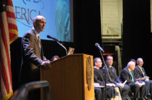 President Vander Hooven on stage behind the podium speaking