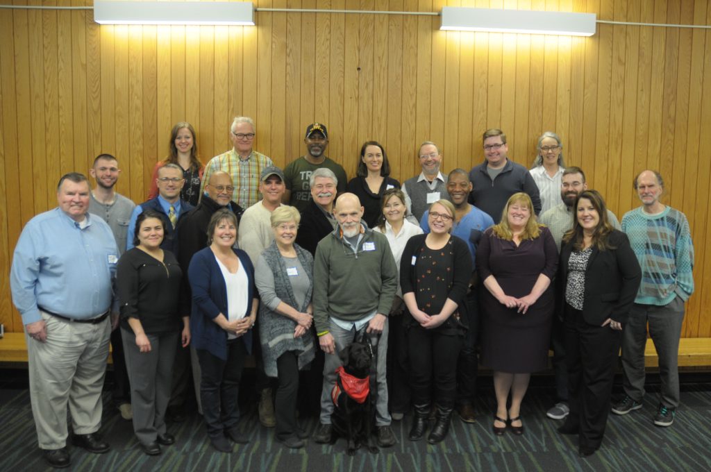 A group of over 20 people pose for a photo.