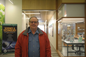 Armand Savoie stands in the hallway of the college's science building.