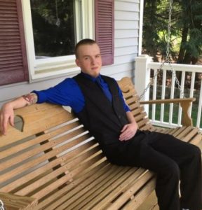 Jonathan Blouin sitting on a bench on a porch