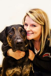 A woman poses with her dog.