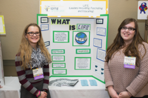 Venture Team standing in front of their tri-fold poster