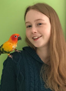 Isabella Marinelli with a colorful bird on her shoulder