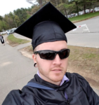 Peter taking a selfie with his graduation cap and gown on