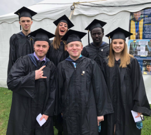 Peter with a group of MWCC friends posing in their graduation regalia