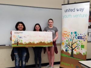 Three girls holding big check