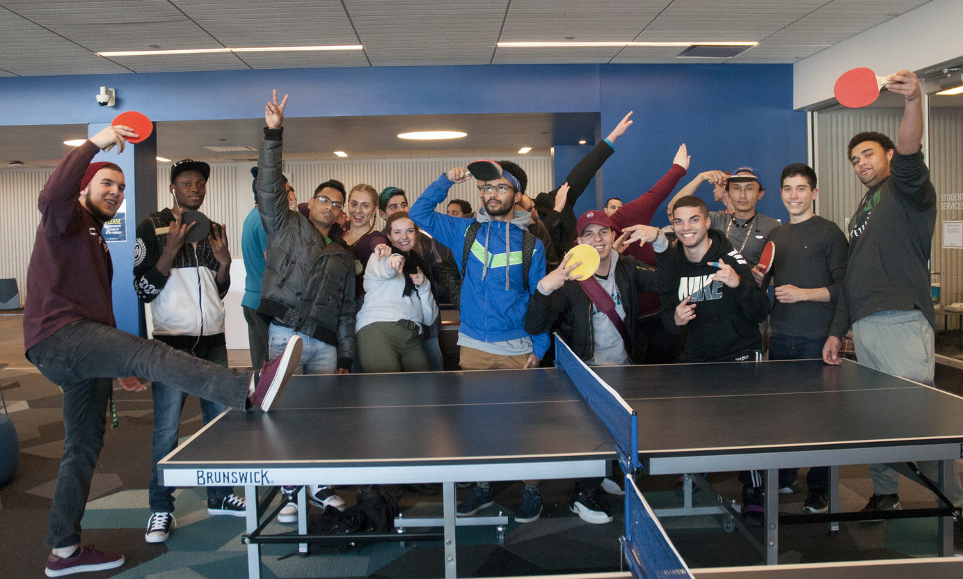 Large group of students in front of the ping pong table.