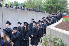 A group of students are lined up as they enter the auditorium for commencement ceremonies.
