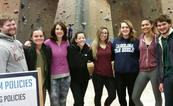 Group of students with their advisor in front of an indoor rockclimbing wall