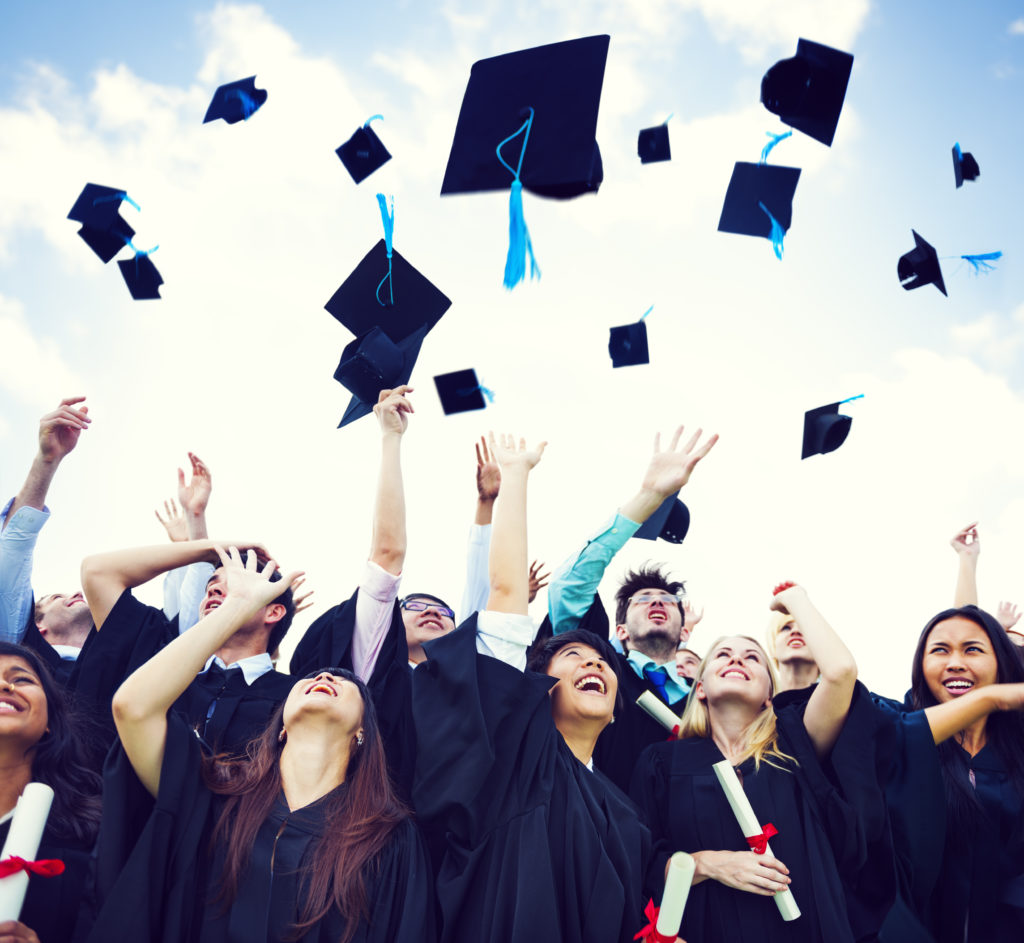 Group of graduates throwing their caps