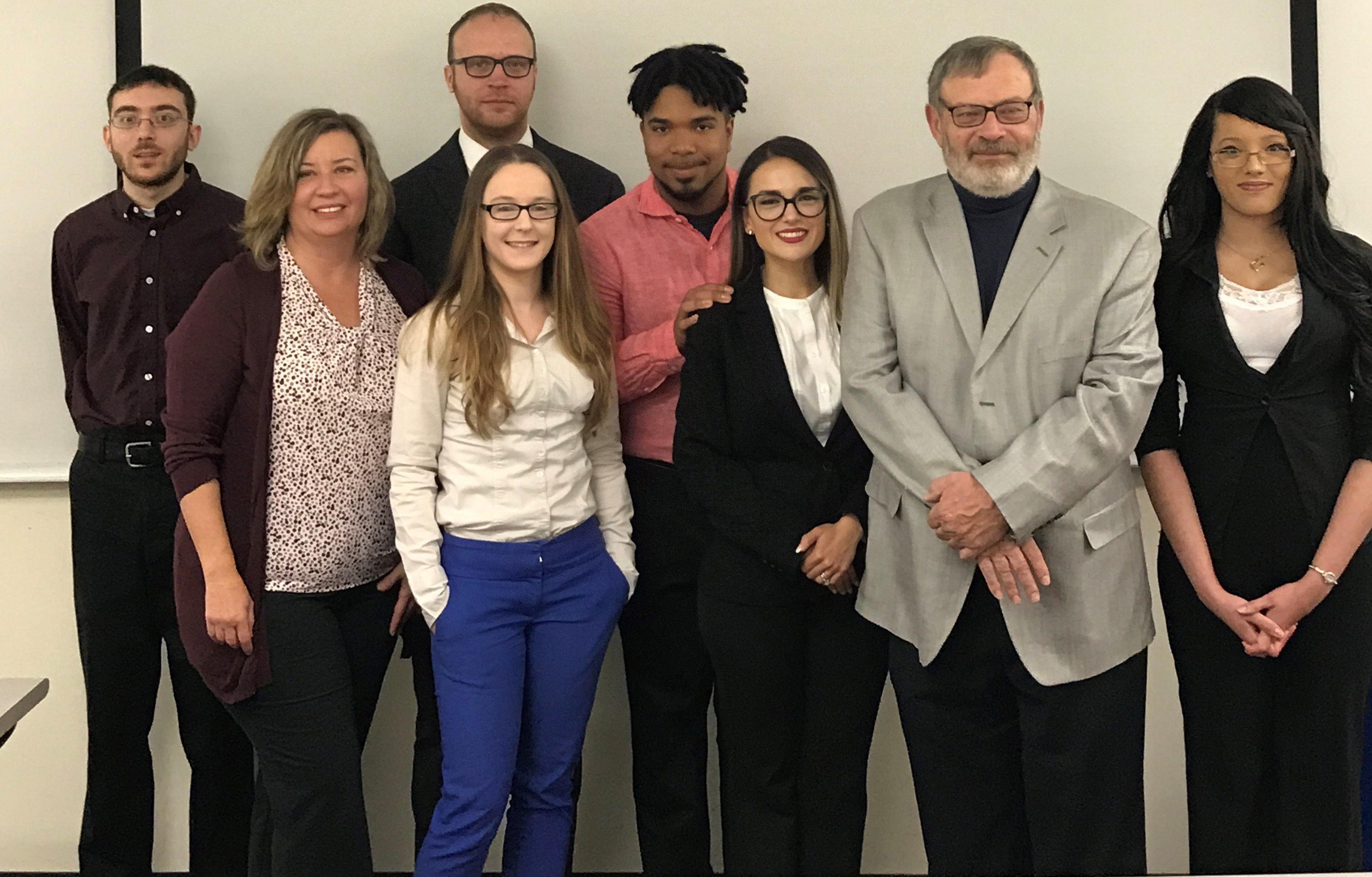 A photo of students in MWCC's 2018 Strategic Management Capstone class. Professor John Reilly and client Diane St. Jean are also depicted.