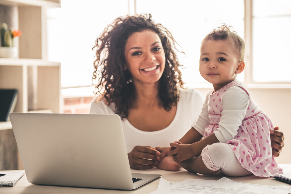 Photo of mother with child and laptop