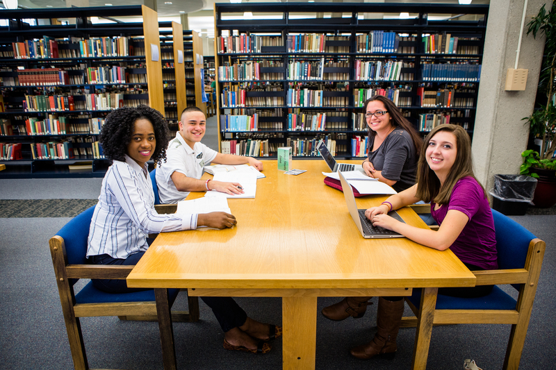 Photos of students sitting at a table in the library