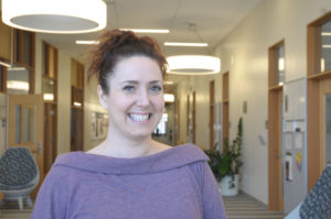 a woman smiles in a hallway