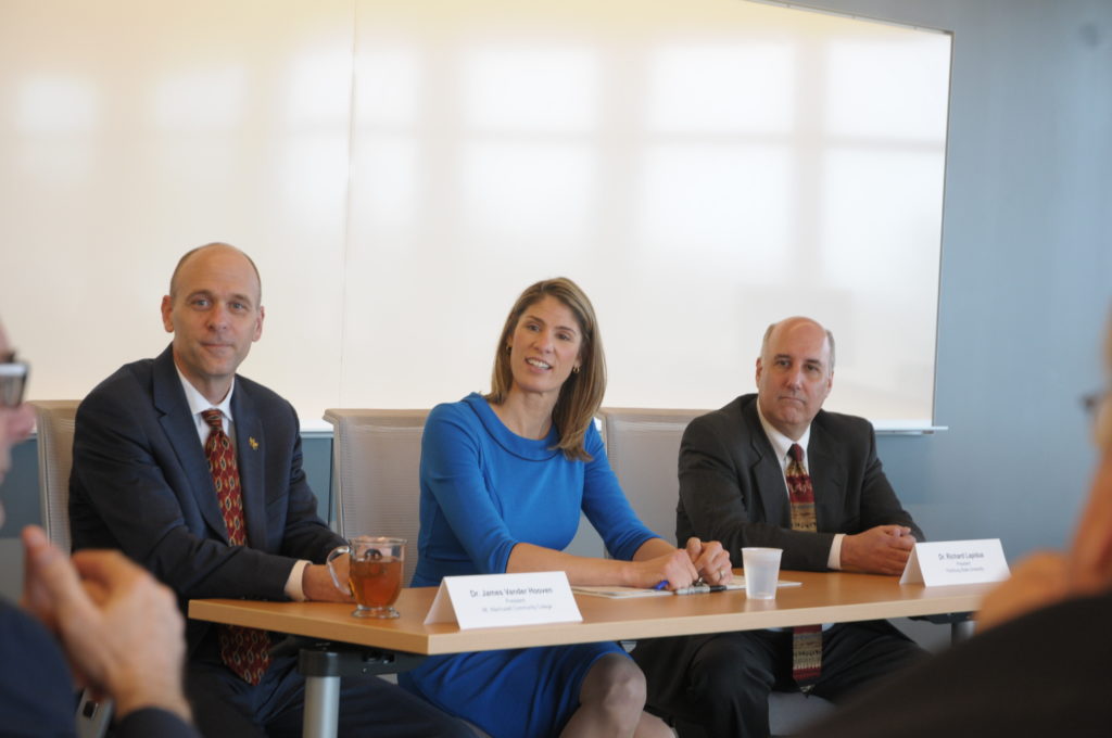 Three people sit at a table.