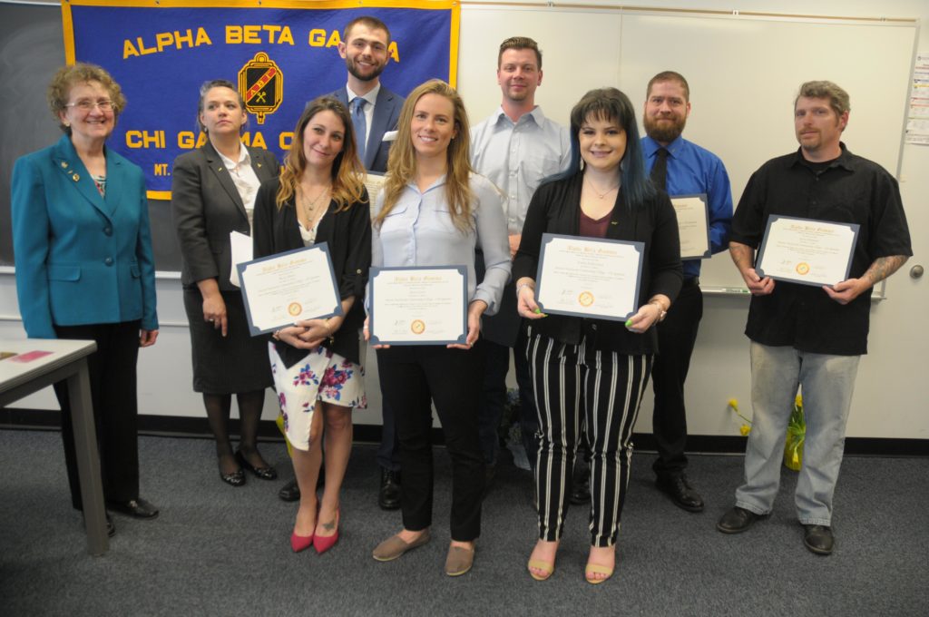 People stand holding awards