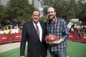 Two people stand next to each other holding a football