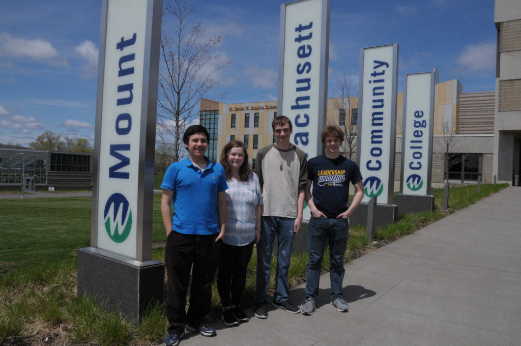 Four students stand outside a building.