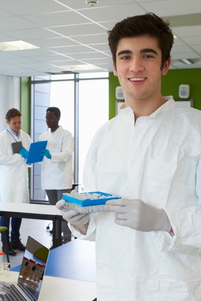 male student in white lab coat with vials