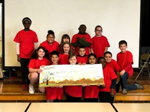 14 kids stand behind a giant check