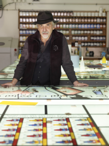 Art Spiegelmann, Cartoonist, standing at a table with a hat