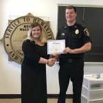 Two people hold up a certificate.