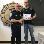 Two people hold up a certificate.