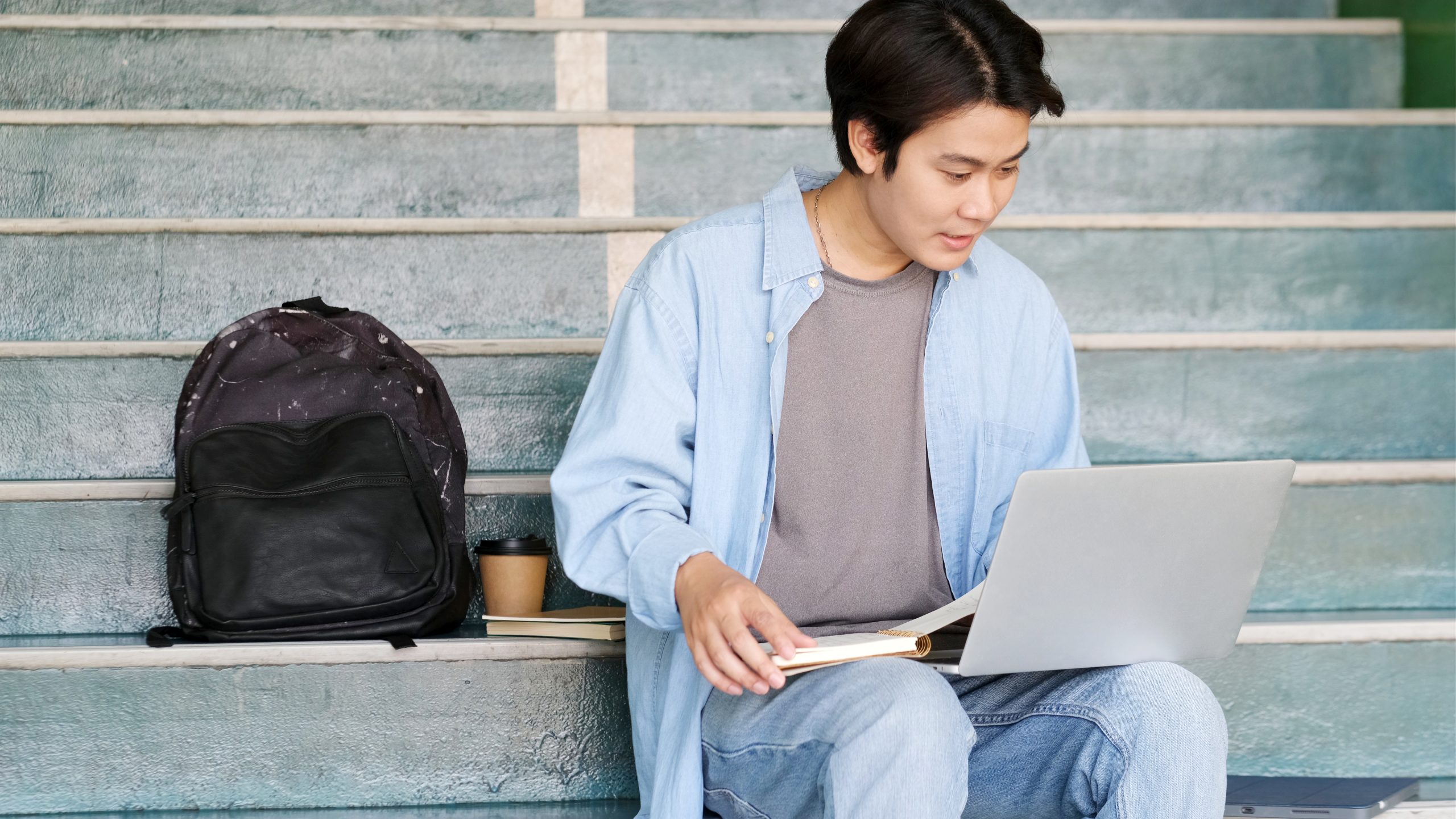 Online education learning, Work from home, Man hand writing on notebook while using laptop computer, Adult male student study online course