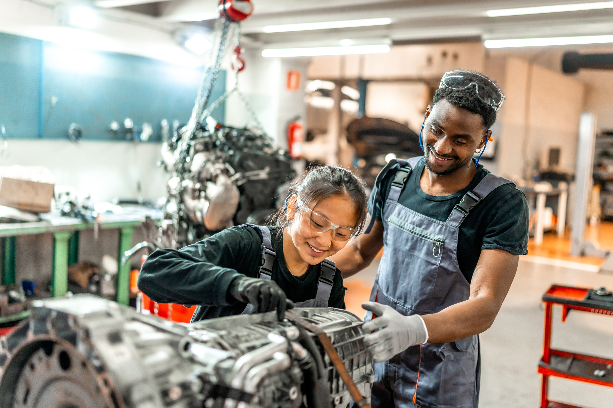 Mechanics working on vehicle engine in auto repair shop