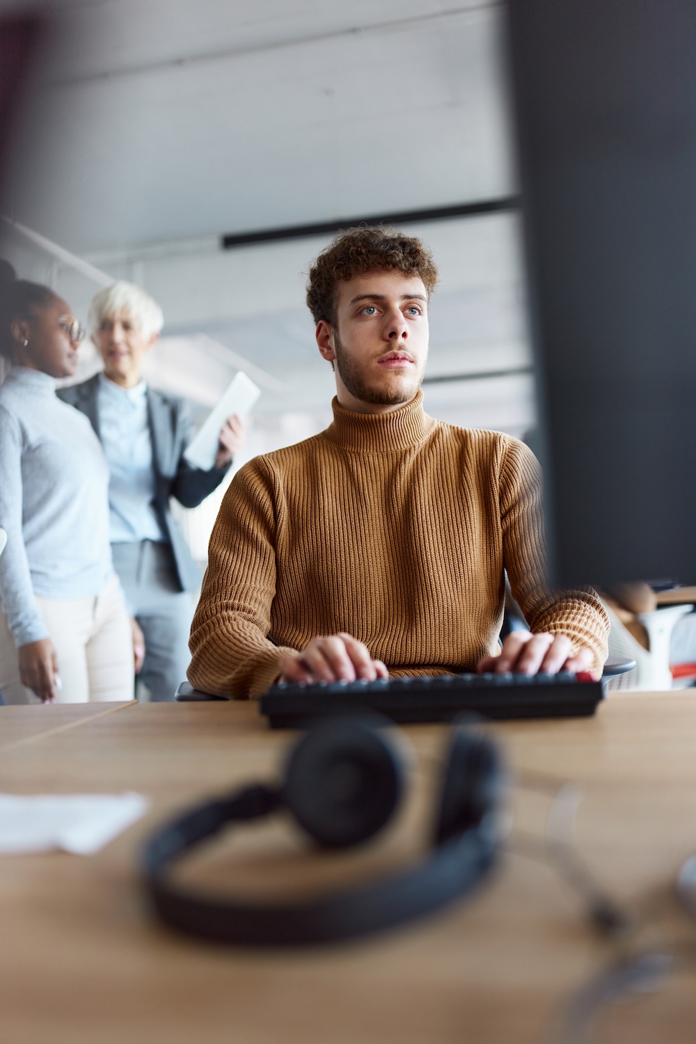 Focused male programmer coding a language on PC in the office.