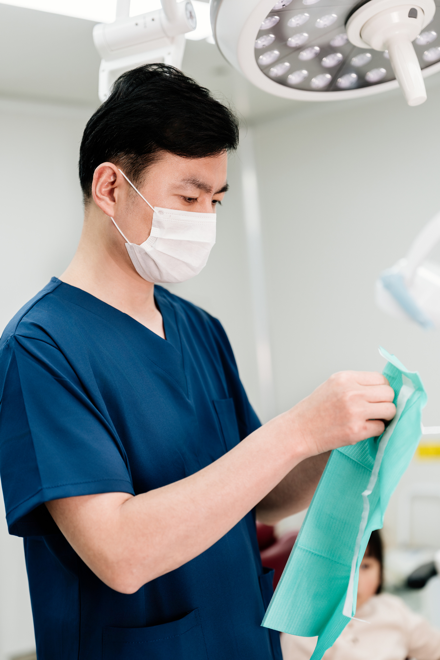 Asian male dentist making preparations in dental operating room. Clinic or hospital concept.