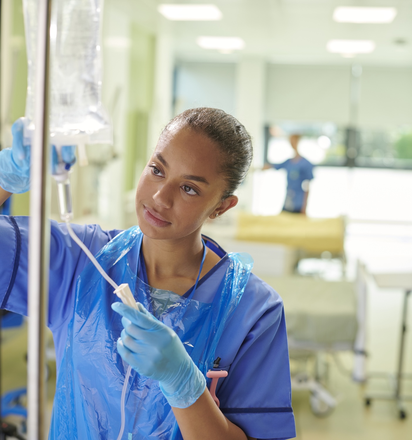 young nurse adjusting iv drip