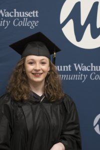 A student is pictured in a graduation cap and gown.