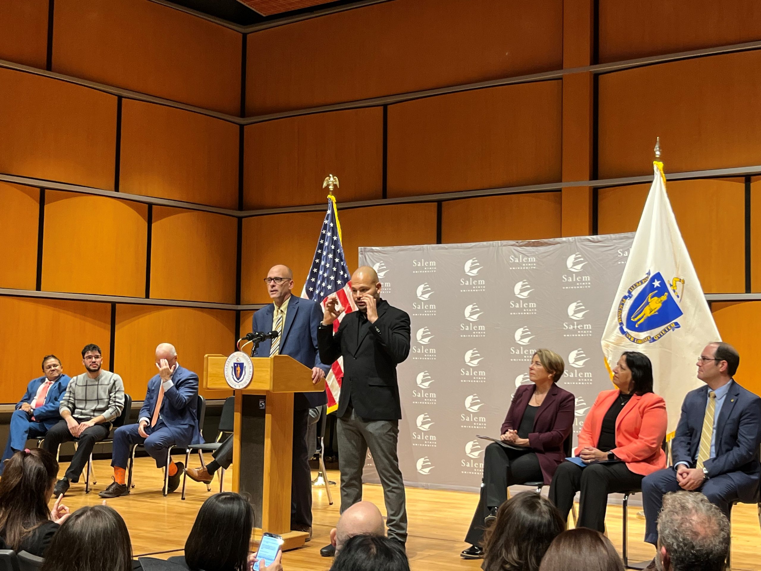 President Vander Hooven speaking at MassGrant Plus press conference as Governor Healey and Lt. Governor Driscoll look on.