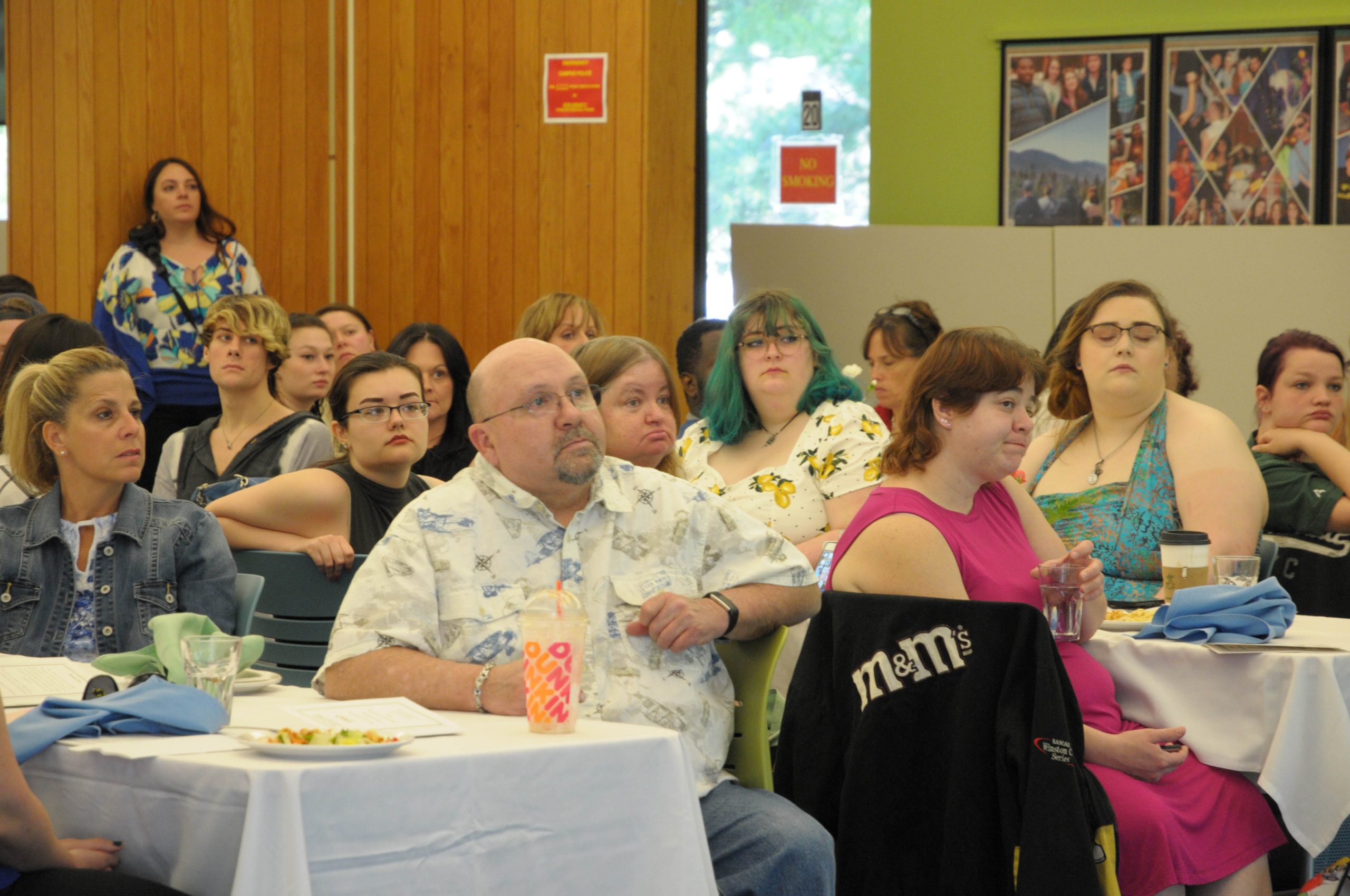 People sit at tables looking right. listening. Learning.