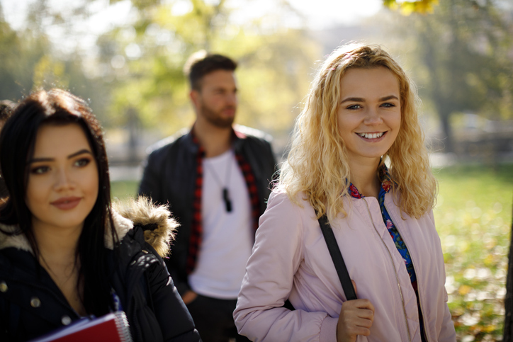 Group of college students walking on university campus