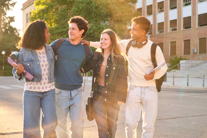 Diverse young adults bonding walking on university campus