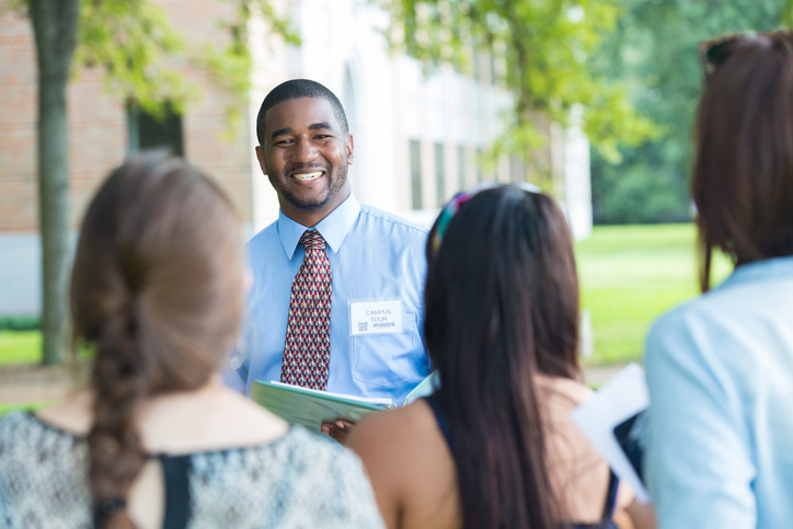 College campus tour guide talking with prospective students outdoors