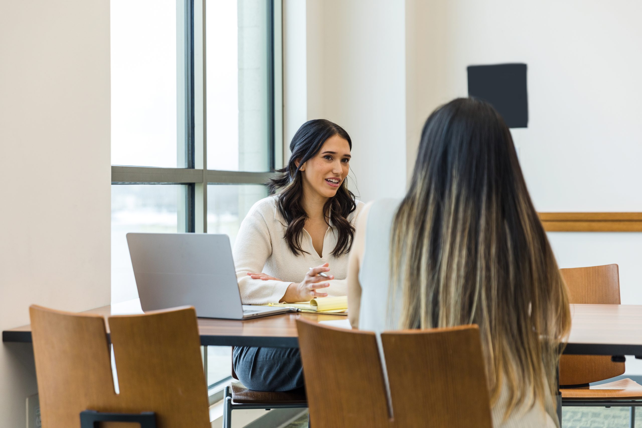 Female business owner asks unrecognizable female job applicant questions