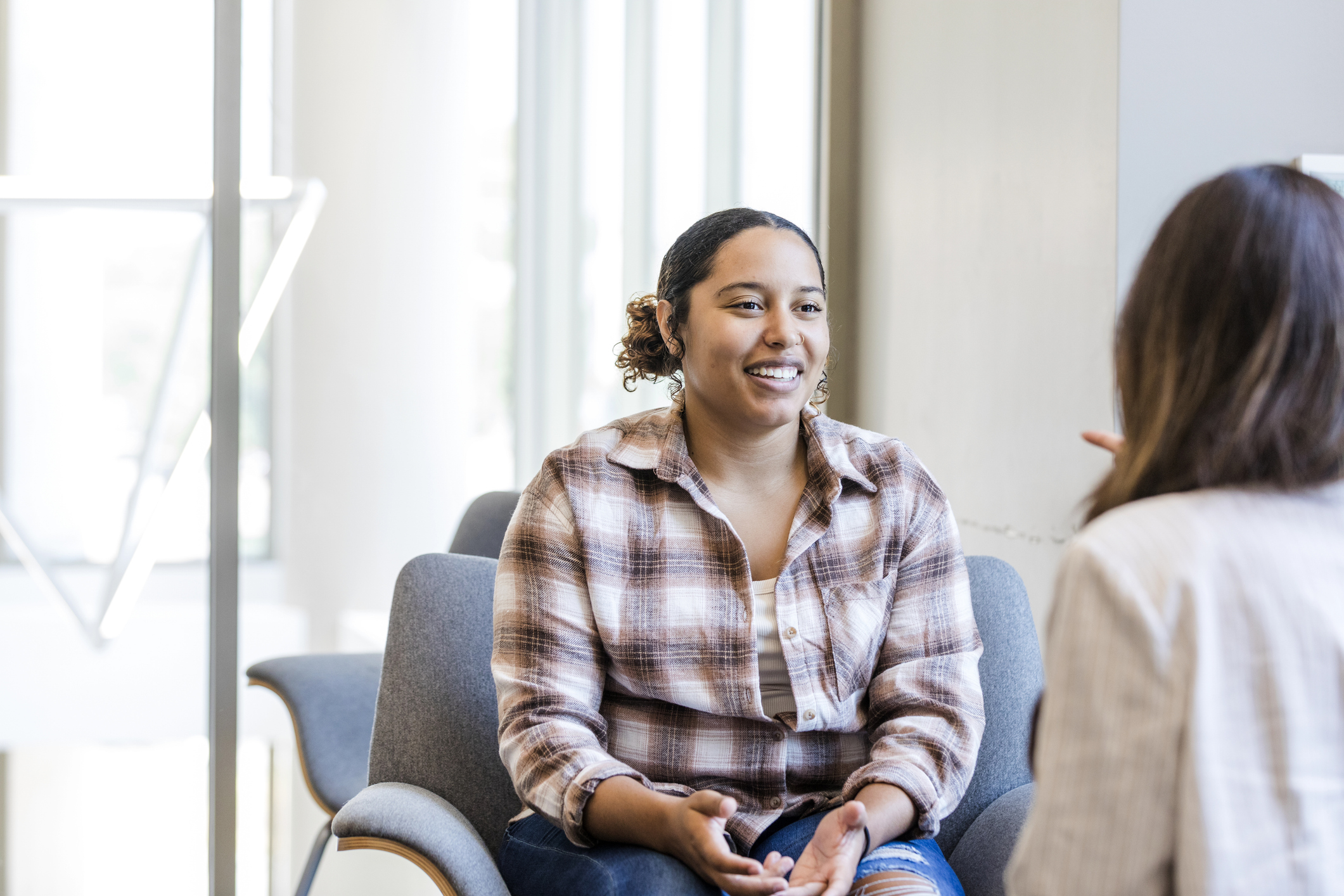 Young adult female smiles while she talks with the to her career counselor
