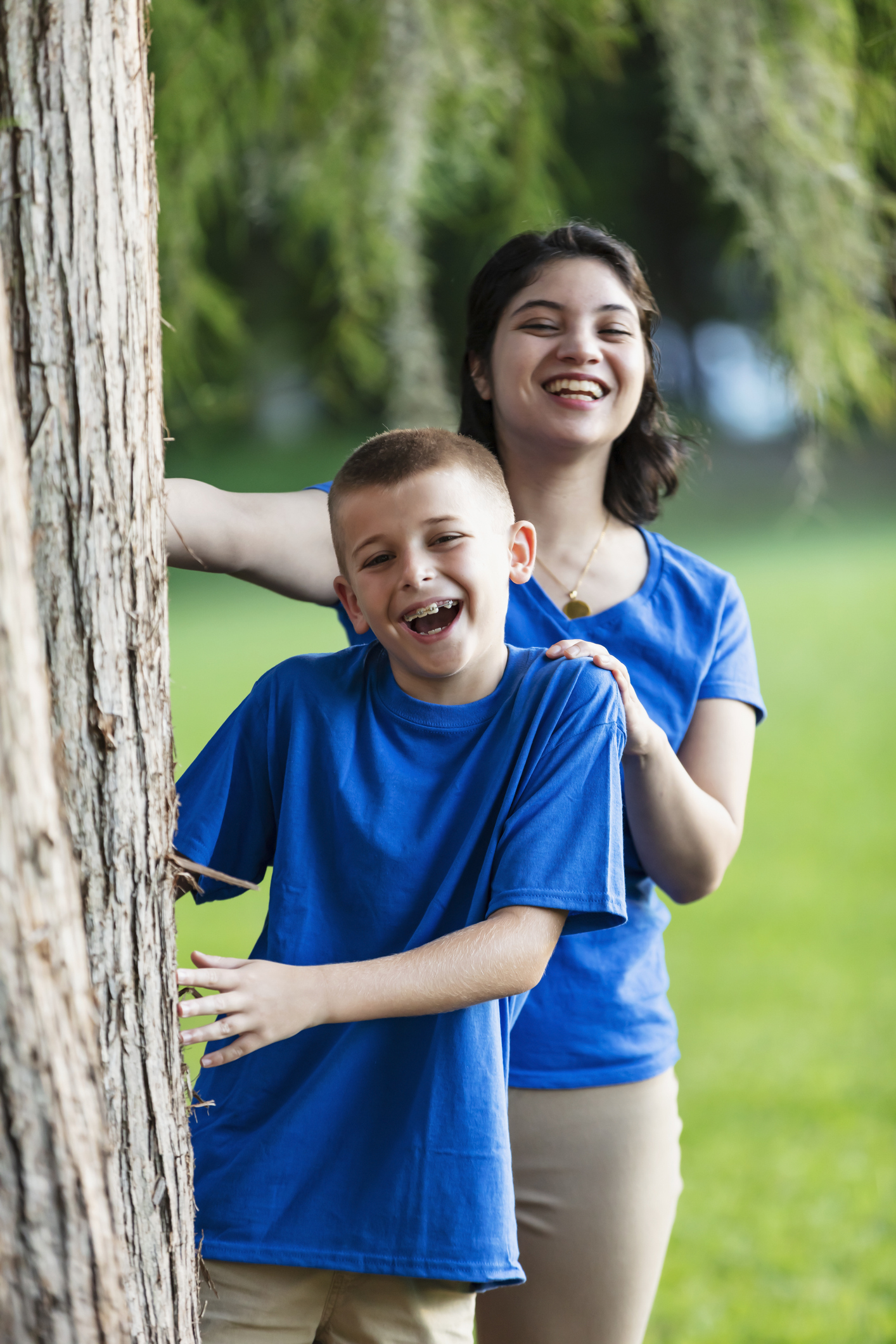Boy with camp counselor in park at summer camp