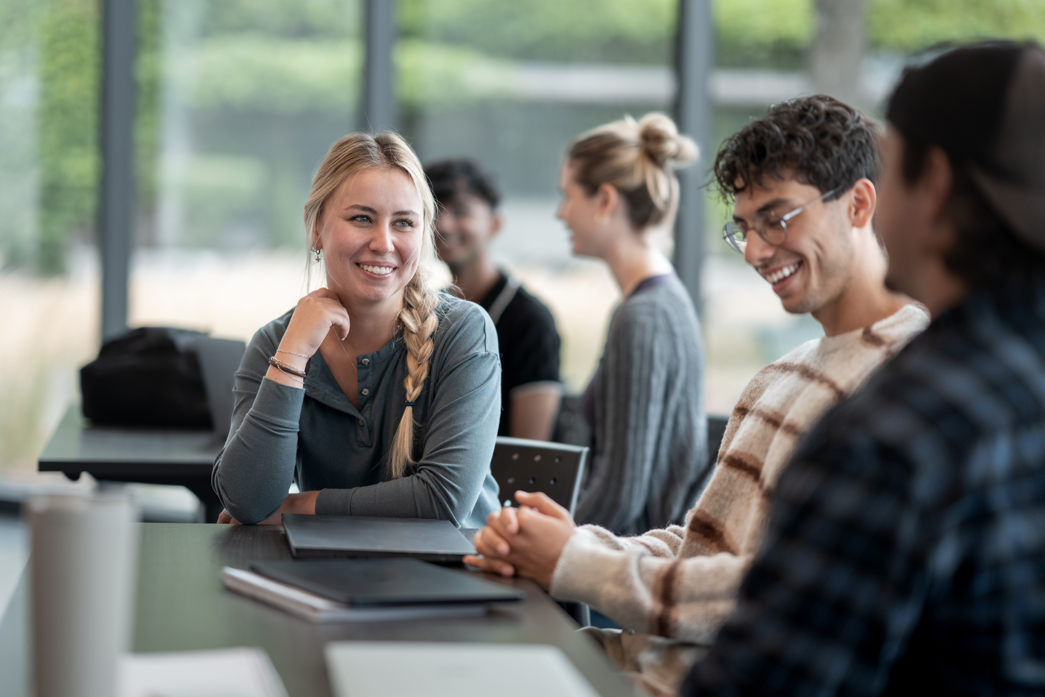 Group of Diverse Students Engaging in Friendly Discussion in Bright Class Setting