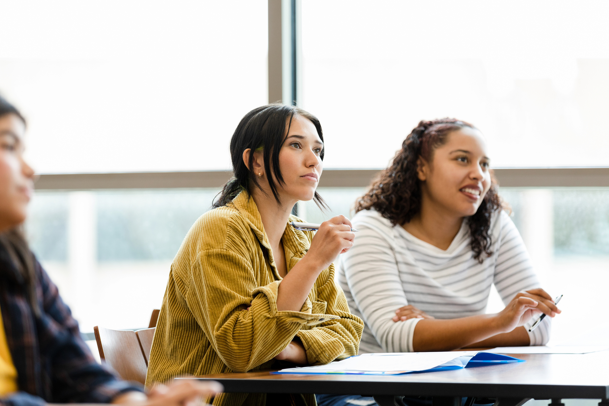 Serious young adult female university students watch video