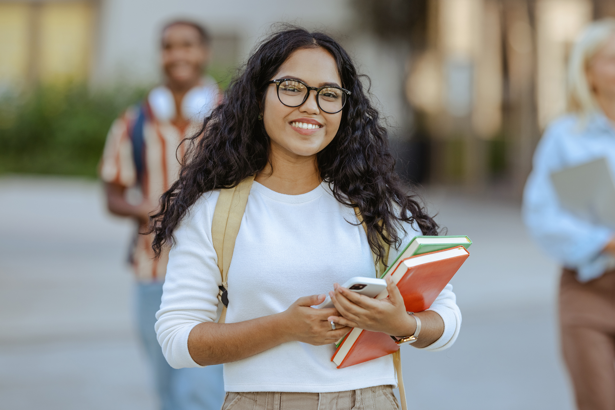 Portrait of a beautiful Latin female student holding books