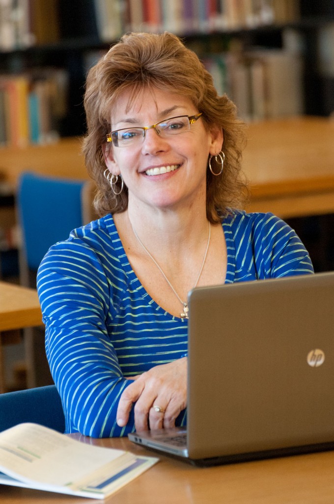 Linda Coyne sitting in front of a laptop