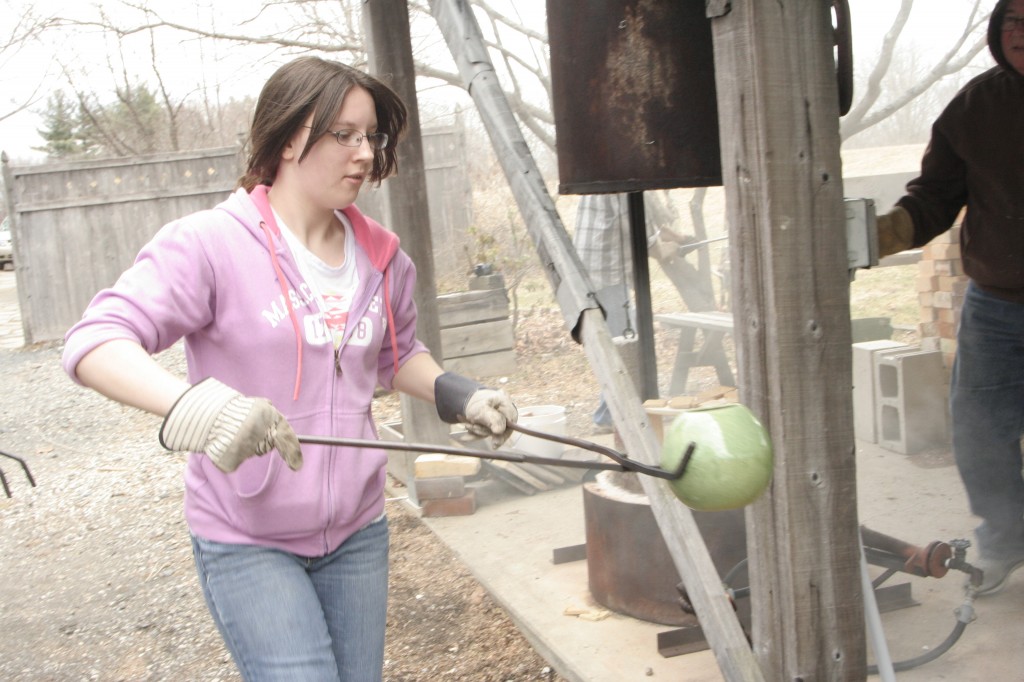 Art student taking a ceramic piece out of the kiln